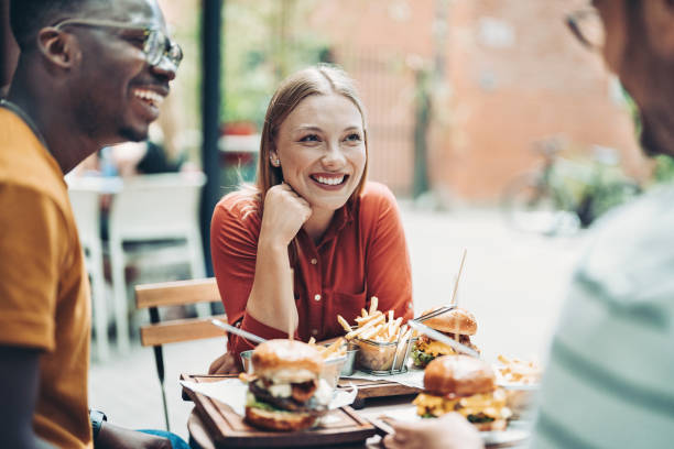 istock Group of young people talking and eating together 1330966678