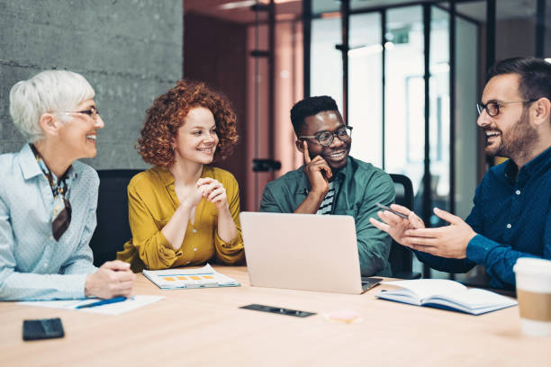 istock Mixed group of business persons talking around a table 1330966683