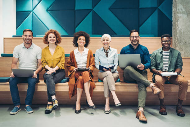istock Mixed group of business persons with mobile devices sitting side by side 1330966687