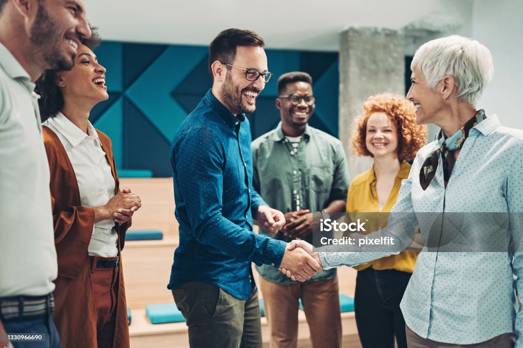 Taking the new opportunity Smiling business persons shaking hands Business Stock Photo