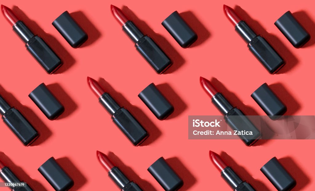Creative pattern fashion photo of cosmetics beauty products red lipstick on a red background Lipstick Stock Photo