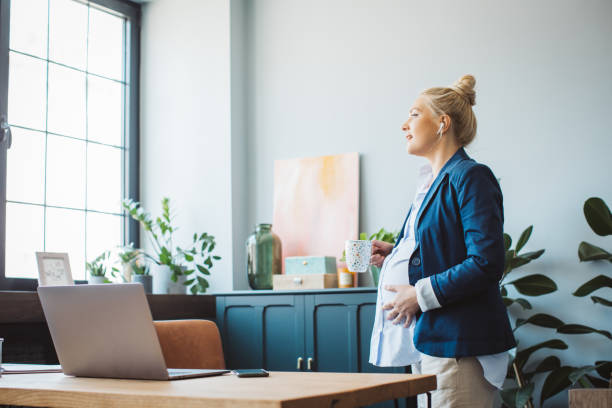 istock Pregnant woman at office working 1330967681