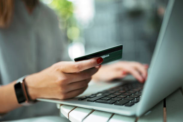 mujer joven con tarjeta de crédito y computadora portátil - pagar fotografías e imágenes de stock
