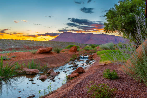 Desert Sunset With River And Red Mountains