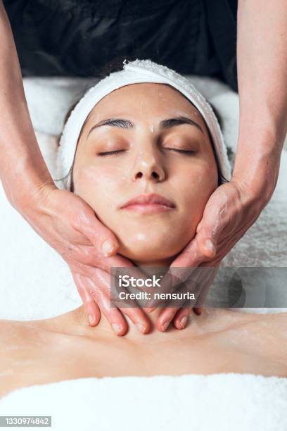 Cosmetologist Making Face Massage For Rejuvenation To Woman While Lying On A Stretcher In The Spa Center Stock Photo - Download Image Now