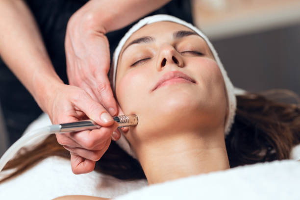 cosmétologue faisant injection de micropigmentation sur le visage pour le rajeunissement tout en étant allongé sur une civière dans le centre du spa. - esthéticienne photos et images de collection