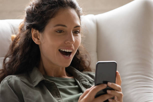istock Astonished amazed young latin lady look on mobile phone screen 1330975031