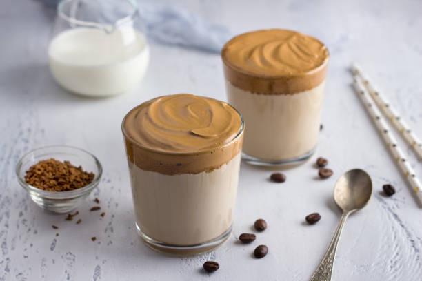 istock Two glasses with Dalgona coffee, cold cocktail with whipped coffee foam, popular trending drink on a light textured background 1330975843