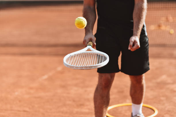 istock Male Tennis Player Bouncing Ball On Racquet 1330976070