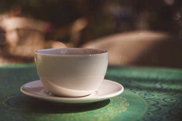 Coffee mug on mint green table outdoor background - soft light effect style pictures. Close-up, mock-up