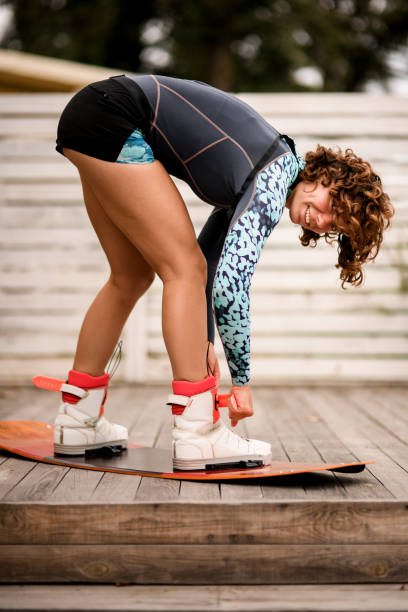 istock happy woman fix her legs in boots on a wakeboarding board 1330977368