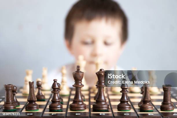 A Chessboard With Spaced Figures In The Background A Boy Out Of Focus Board Game Of Chess Tournaments And Schools For Young Chess Players Stock Photo - Download Image Now