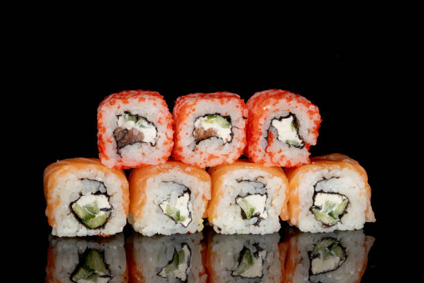 istock Philadelphia roll with salmon, cheese and cucumber on a black background with reflection. Sushi Philadelphia 1330981439
