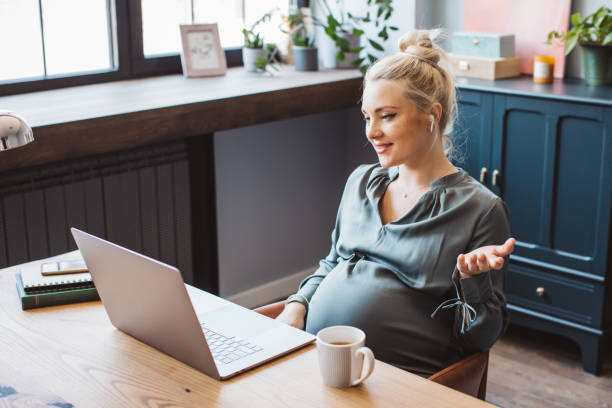 istock Pregnant woman at office working 1330984213