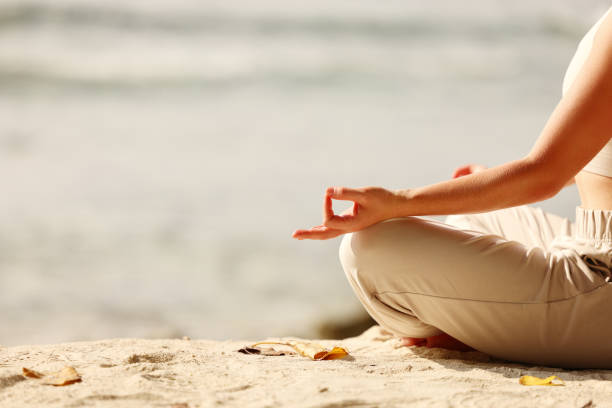 istock Faceless lady meditating in Lotus pose on beach 1330984312