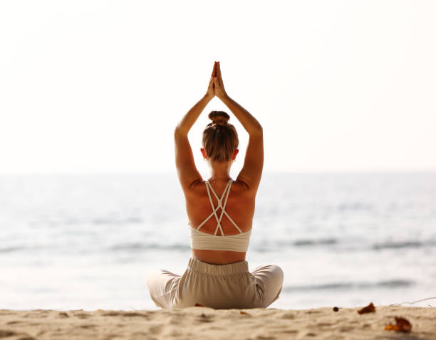 istock Calm woman meditating on beach at sunset 1330984341