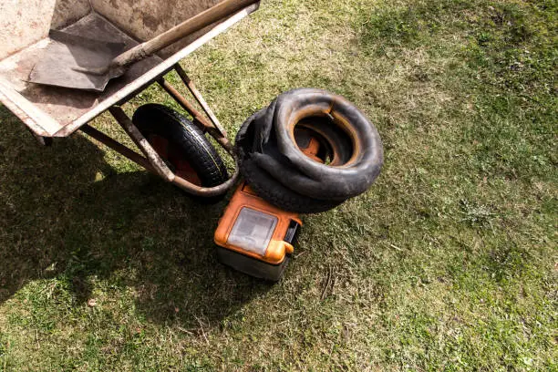 Photo of A shot of inner tubes and tires in a wheelbarrow.