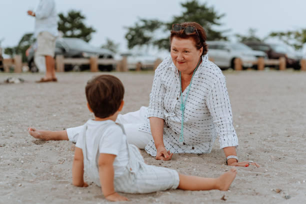 babcia bawi się z wnukiem na plaży - uncle zdjęcia i obrazy z banku zdjęć