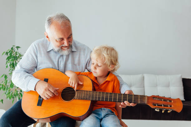 istock Grandfather And Grandson Playing Guitar 1330991211