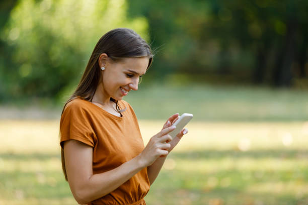istock A Young Woman is Walking in Nature and Using a Smart Phone. 1330992143