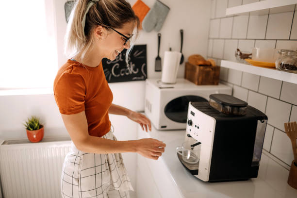 First coffee Young woman making coffee on coffee machine at home coffee maker stock pictures, royalty-free photos & images