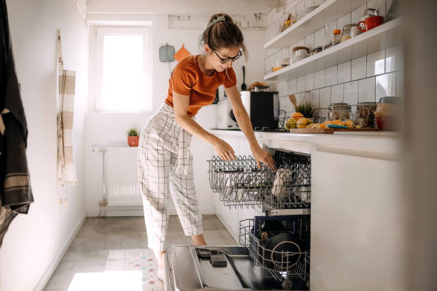 I love when everything is clean Young woman putting dishes in dishwashing machine dishwasher stock pictures, royalty-free photos & images