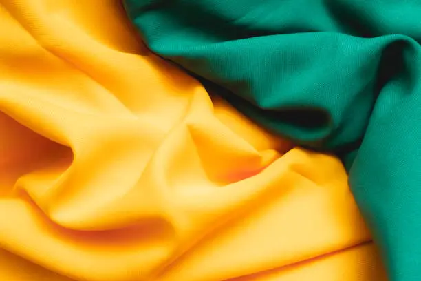 Photo of Brazil background. Fabric texture background with green and yellow colors reminding the colors of the Brazilian flag. Top view photo.