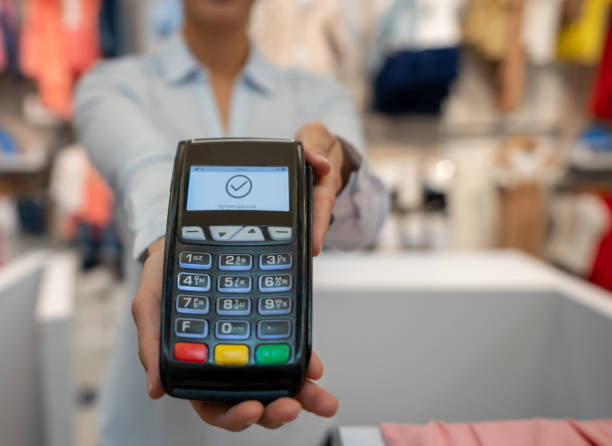 paying by card while shopping at a clothing store - credit card reader imagens e fotografias de stock