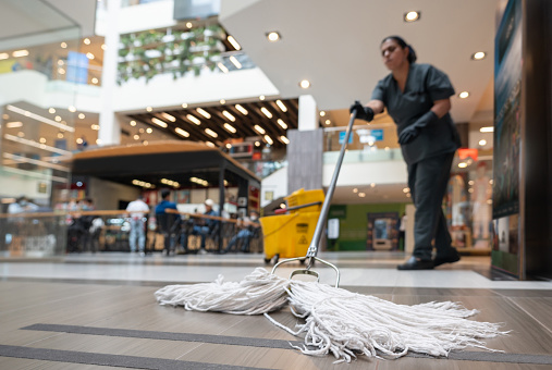 Latin American cleaning lady mopping the floor at a shopping center