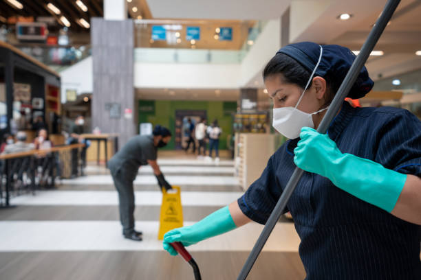 istock Cleaning ladies mopping the floor at a shopping mall while wearing facemasks 1330995594