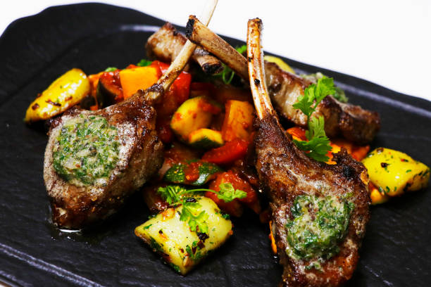 grilled prime lamb rack with herb butter and ratatouille grilled prime lamb rack with herb butter and ratatouille rack of lamb stock pictures, royalty-free photos & images