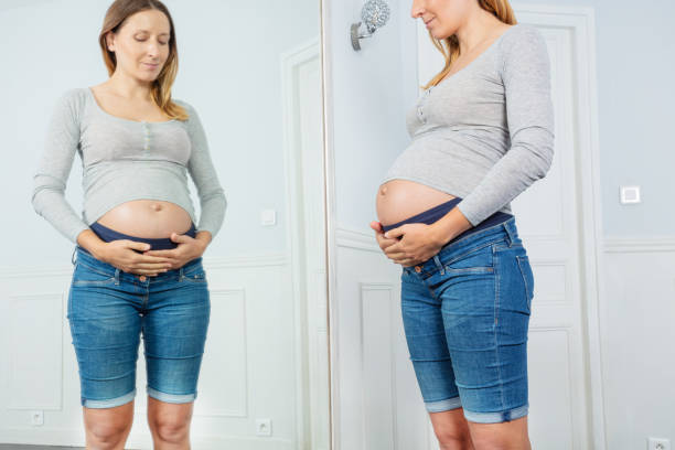 istock Happy pregnant woman posing before the mirror 1330997094