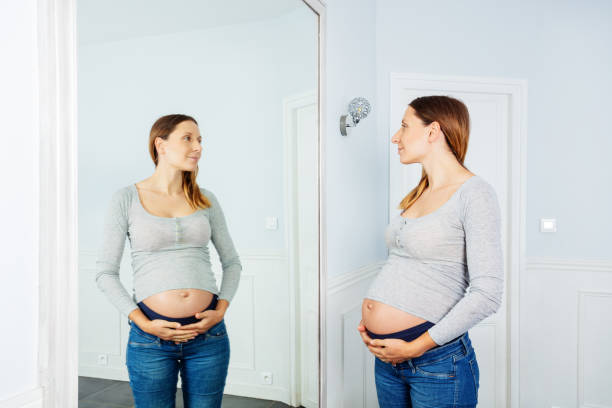 istock Late stage pregnancy woman posing near mirror 1330997100