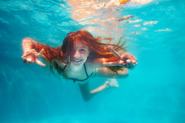 istock Girl with long red hair pose underwater gesturing 1330997145