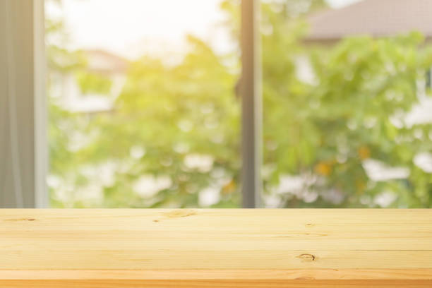 istock Empty wood table top with abstract blur window interior with green garden view background 1330997214