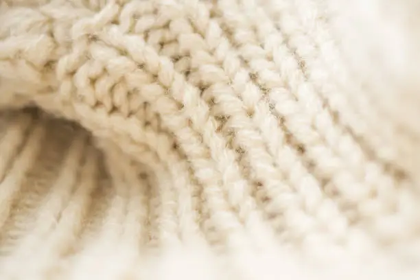 Photo of closeup beige knitted woolen fabric background