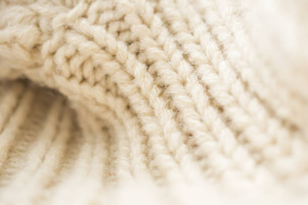 closeup beige knitted woolen fabric background - lã imagens e fotografias de stock