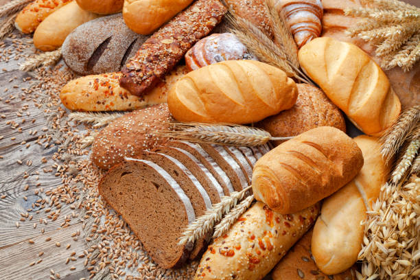 istock Bakery product assortment with bread and buns on wooden table 1330999936