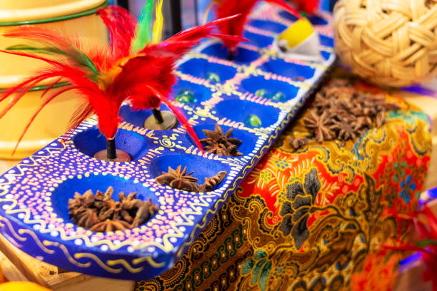 close up of assorted traditional toys in Sputheast Asian Traditional game set, Congkak, shuutercock, rattan ball, spining top and some spice on top of batik cloth malaysian batik stock pictures, royalty-free photos & images
