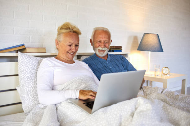 istock Retired senior couple using laptop while sitting in bed 1331010196