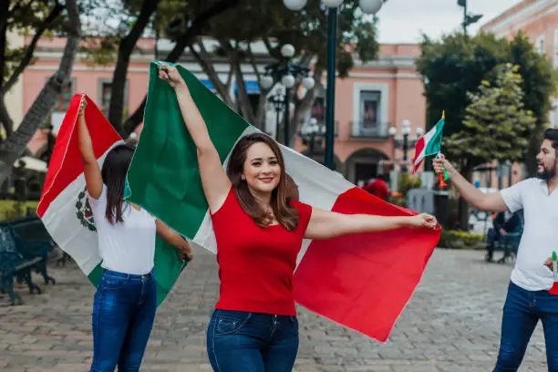 Proud mexican woman holding a flag of Mexico