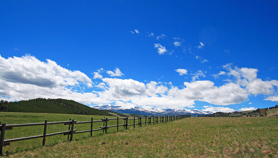 Round rail fence under blue sky in the Bighorn Mountain range of  Rocky Mountains in Wyoming USA