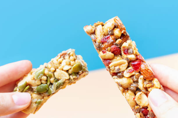 istock Female hands hold a protein bars on blue and brown background. 1331028565