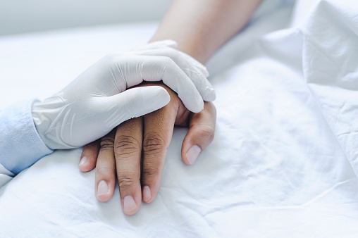 Los médicos varones usan guantes médicos que sostienen las manos tocistas hombre paciente con amor, cuidado, ayuda, alentar y empatía en la sala del hospital de enfermería. concepto médico fuerte y saludable photo