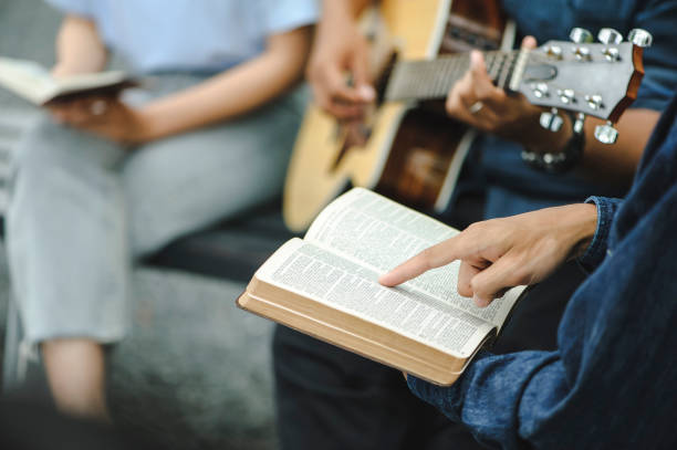 성서와 함께 기도하는 손을 들고 있는 기독교 가족 그룹. 기타를 연주하여 추수감사절 찬양을 노래하고 믿음으로 하나님의 축복을 구하십시오. 성경을 읽고 복음을 나누기 - religious leaders 뉴스 사진 이미지
