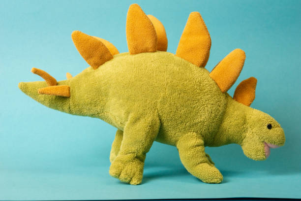 istock dinosaur doll isolated on blue background 1331030723