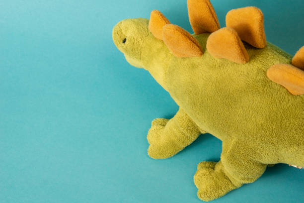 istock dinosaur doll isolated on blue background 1331030808