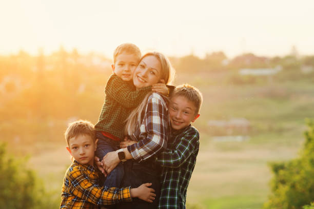 Portrait of Chinese mother embracing her children isolated over white background.