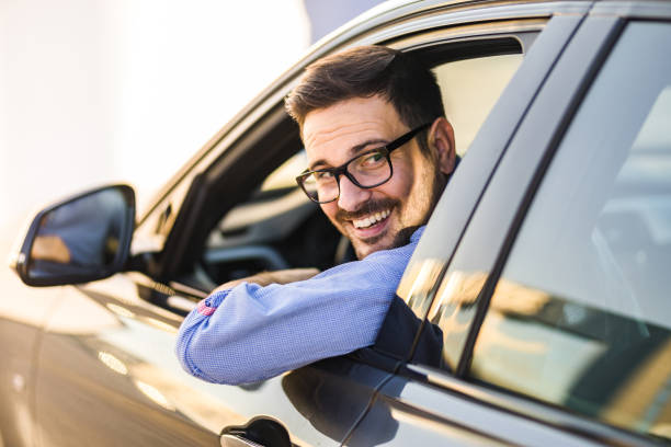 jeune homme heureux conduisant une voiture en marche arrière. - car driving men reversing photos et images de collection