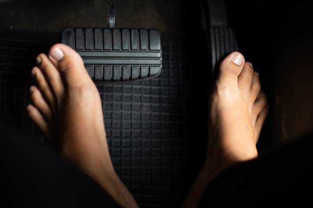 istock man taking off his shoes while driving 1331041644